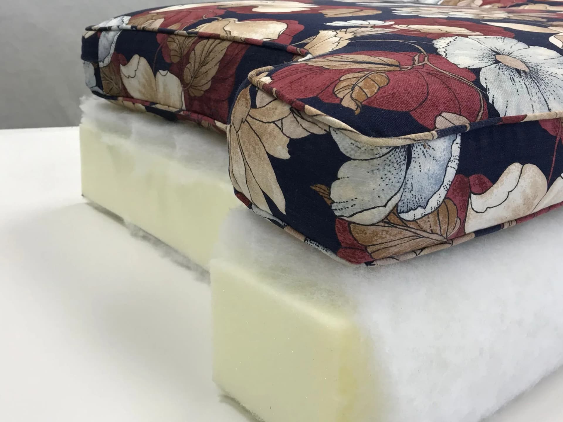 Technician measuring sagging sofa cushion foam for replacement.