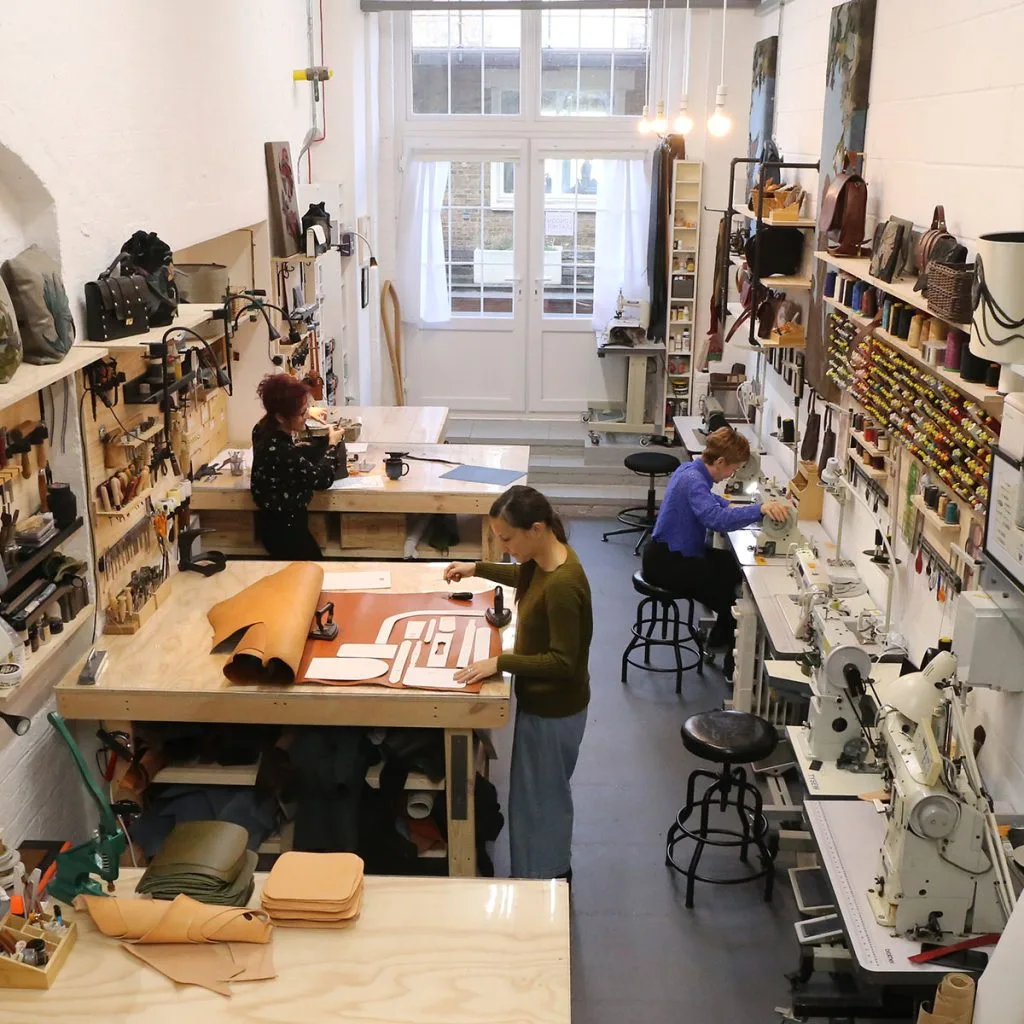 Designer Handbag Restoration Workshop and Leather Artisans Leather artisans restoring designer handbags in a professional restoration workshop
